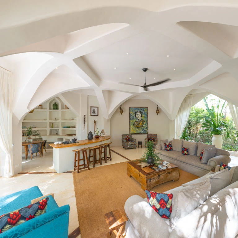 Light-filled living area at Mbingu Villa in Xanadu Luxury Villas & Retreat, Zanzibar, featuring spacious sofas, a stylish bar and elegant arched architecture.