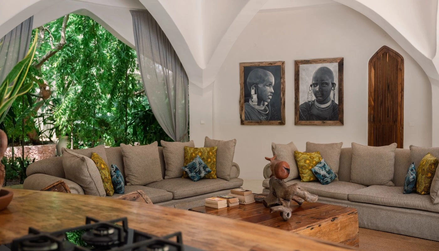 Inviting lounge area at Mbingu Villa in Xanadu Luxury Villas & Retreat, Zanzibar, featuring elegant sofas, African artwork and views of the lush tropical garden.