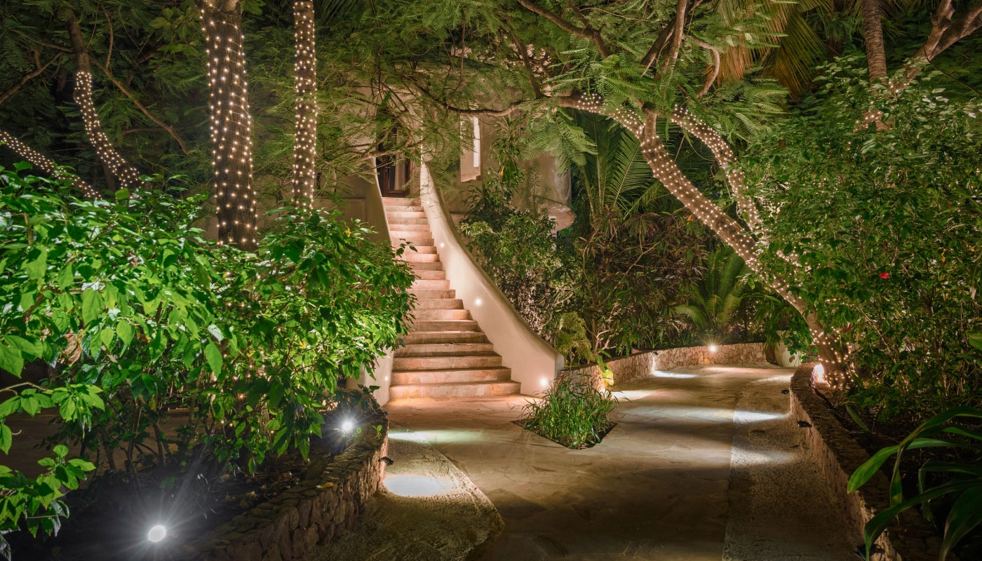 Beautifully illuminated garden at Mbingu Villa in Xanadu Luxury Villas & Retreat, Zanzibar, featuring an elegant stone staircase, lush tropical greenery and sparkling fairy lights.