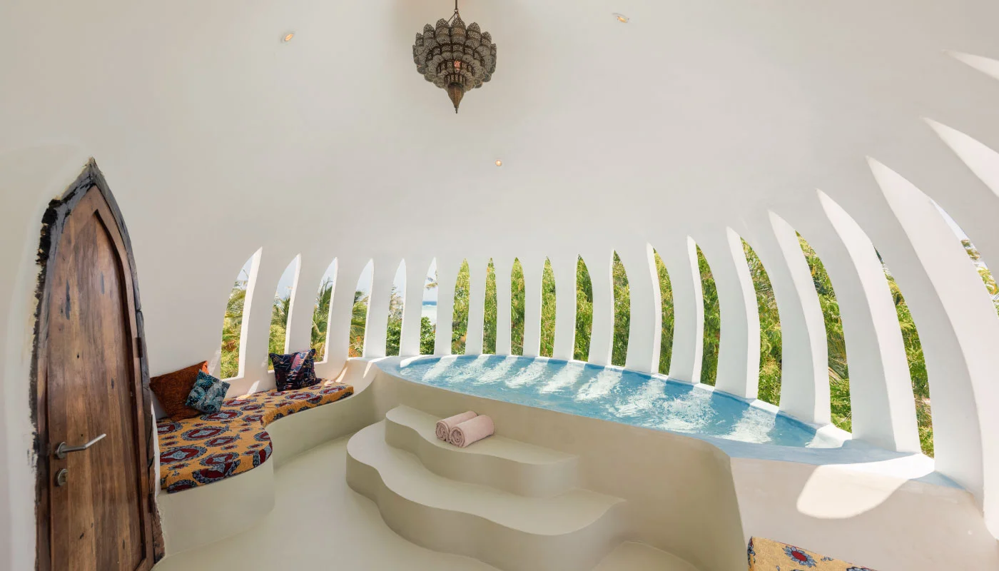 Private rooftop pool at Mbingu Villa in Xanadu Luxury Villas & Retreat, Zanzibar, featuring a curved plunge pool, a cozy seating area and distinctive arched architecture.