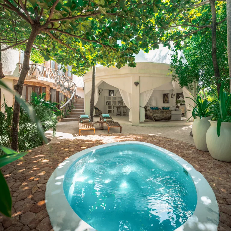 Idyllic private pool at Mlima Villa in Xanadu Luxury Villas & Retreat, Zanzibar, surrounded by shady trees and featuring comfortable sun loungers and an open lounge area.